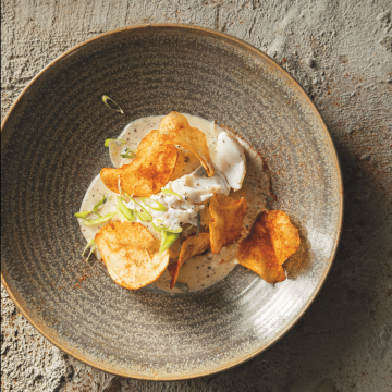 Smoked hake with black pepper cheese sauce and crispy potato skins